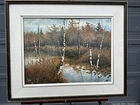 Framed view of signed landscape painting showing birch trees by the water with reflections, naturalistic autumn tones, signed 'Kato' lower left.