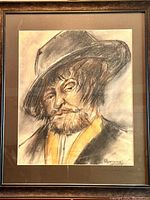 Full view of framed sketch featuring portrait of bearded man in hat