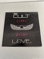 Front cover of The Cult "Love" vinyl album featuring band name, album title, and winged symbol.