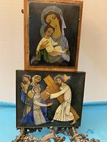 Photograph of both religious paintings vertically stacked, showing the Madonna and Child image on top and Jesus carrying the cross on bottom with metal framing.