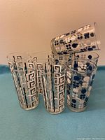 Set of eight MCM vintage tall water glasses on a blue cloth background, showing the two styles.