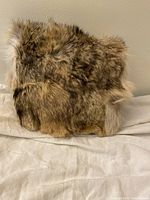 Front side showing light brown and beige fur surface of the muff purse