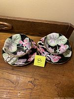 Front view of two tea cup and saucer sets on wooden surface