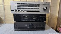 Front view of the three stacked audio components: old tube amp on top with analog tuner, Sony dual cassette deck in the middle, and Technics amplifier at the bottom.
