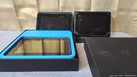 Three BlackBerry PlayBook tablets shown together with BlackBerry retail box insert and outer box.