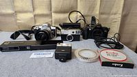 Lot arranged with cameras and accessories including Minolta X-700, Canon Sure Shot, Kodak cameras, flash unit, Kalimar exposure meter, Kenko flash bulb pack, spiral reflector.