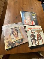 Vinyl record covers on wooden table showing Anne Murray, Loretta Lynn, and Grand Ole Opry albums.