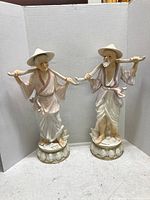 Front view of paired Asian elderly man and woman ceramic statues with shoulder bars, showing condition and overall height.
