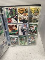 Photo showing NASCAR trading cards in plastic sleeves within a binder, featuring Bobby Labonte among drivers.