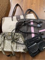 Overview of five bags: two large totes (beige/brown and black with pink stripes), small faux snakeskin purse, black crossbody Jaclyn Smith purse and small black zippered bag