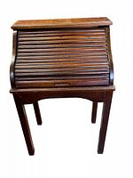 Front view of the vintage child's mini roll top desk showing the closed slatted roll top and wooden handle.
