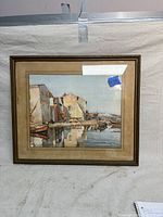 Full view of vintage framed watercolor artwork showing harbor with buildings and boats, framed in beige matte and brown wood frame