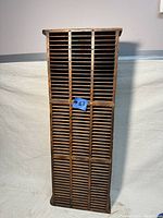 Full front view of the vintage industrial wooden cubby cabinet showing all horizontal slots in three vertical columns.