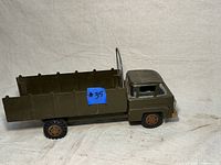 Front-side view of the green metal Marx toy truck showing flatbed and fold-down sides