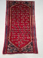 Full view of the Persian hand knotted wool rug with red field and geometric patterns.