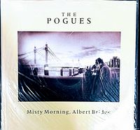 Front view of The Pogues vinyl record sleeve featuring Misty Morning, Albert Bridge with visible surface wear and creasing.