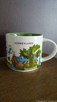 Side view of Starbucks You Are Here mug showing colorful Adventureland themed artwork and "Disneyland" text near handle.
