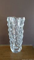Front view of the clear crystal sculptured vase showing the complex geometric pattern covering the entire surface.