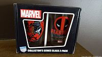 Box front view showing the two Marvel Deadpool glasses through the window. Original packaging with Marvel logo and Collector's Series Glass 2-Pack text.
