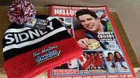 Sidney Crosby Tim Hortons Timbits winter hat with tags placed next to Hello Canada magazine cover featuring Sidney Crosby, Canada’s Golden Moments Special Collectors Issue from March 15, 2010