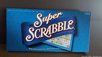 Front view of the Super Scrabble box showing the name, year, and theme.