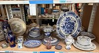 Overall assortment of vases, plates, bowls and serving pieces on shelf