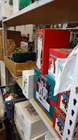 Shelves holding multiple boxes of holiday decorations and ornaments, including a green box and red boxes with Christmas characters.