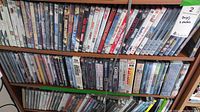 Shelf with three rows of DVDs showing various movie titles across children's, comedy, and drama genres.