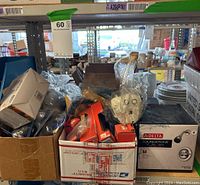 Wide view showing boxes containing light bulbs, Delta shower head in retail box, DVD-R discs, and shoe shine brushes