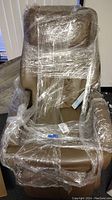 Front view of wrapped tan massage chair