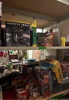 Shelf with multiple toy items including boxed remote control vehicles, action figures, and puzzles.