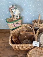 Various sizes and styles of woven baskets including a decorated picnic basket with fabric lining and smaller trays inside a large basket