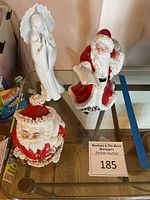 Full view of all three items: white Angel figurine, squat Santa Claus coin bank, and tall Royal Doulton Father Christmas