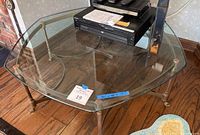Overview photo showing the full square glass coffee table with iron frame and glass lower shelf. Seller note measuring dimensions on blue tape visible on glass.