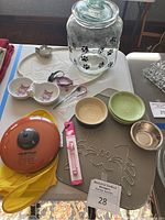 Overview of cat item set with mats, bowls, collar, treat container, and pot holder on table