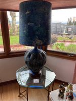 Full view of lamp on glass table in front of window