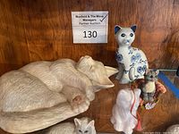 Overview photo showing all four ceramic cat figurines together with a wooden background.