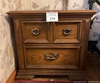 Front view of the wood night stand showing the two upper drawers with brass handles and one large bottom drawer with a brass handle.