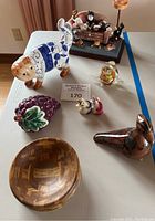 Overall collection on table showing most decorative items including cats, birds, grapes, unicorns and wood bowl