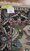 Close-up of the rug corner showing multicolor floral pattern with beige fringe, and a label showing measurements 4.5 x 6 feet.