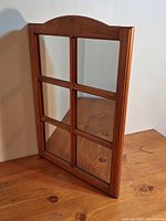Wooden framed mirror with six rectangular glass panels, natural wood grain visible