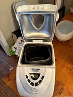 Top view of the breadmaker with lid open showing the bread pan inside.