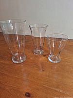 Three clear glass vases of different sizes arranged from tallest to shortest