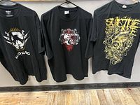 Three black heavy metal band t-shirts hanging side by side: Waste, Necrotek, Suicide