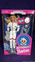 Front view of Astronaut Barbie doll in its original box showing the doll, space suit, moon rock accessory, and branding.