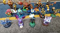 Full view showing all 13 Skylanders characters arranged on a carpet, showing various colors and creatures