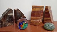 Photo showing all six items including two pairs of bookends and two glass paperweights on display.
