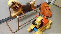 Photo showing three vintage riding toys: Wonder Pony rocking horse with metal frame, orange Playskool hippopotamus riding toy, and yellow Fisher-Price puppy rocking horse.