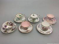 Photo showing all six assorted bone china teacup and saucer sets together on grey surface.