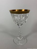Front view of the crystal wine glass showing the gold encrusted acid-etched rim and cut crystal bowl.